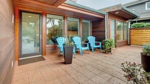 A patio with wooden flooring, a sliding glass door, and blue Adirondack chairs. - Beautiful Seattle Home w/ Patio ~ 9 Mi to Downtown (Seattle)