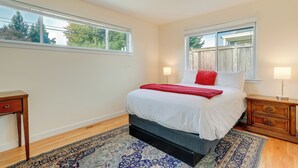 A bedroom with a bed, nightstands, a window, and a view of the outdoors. - Beautiful Seattle Home w/ Patio ~ 9 Mi to Downtown (Seattle)