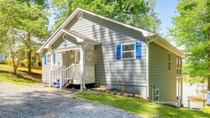 A single-story house with a porch, a small deck, and a dock extending into a body of water. - Lakefront Eatonton Getaway w/ Dock & Grill! (Eatonton)
