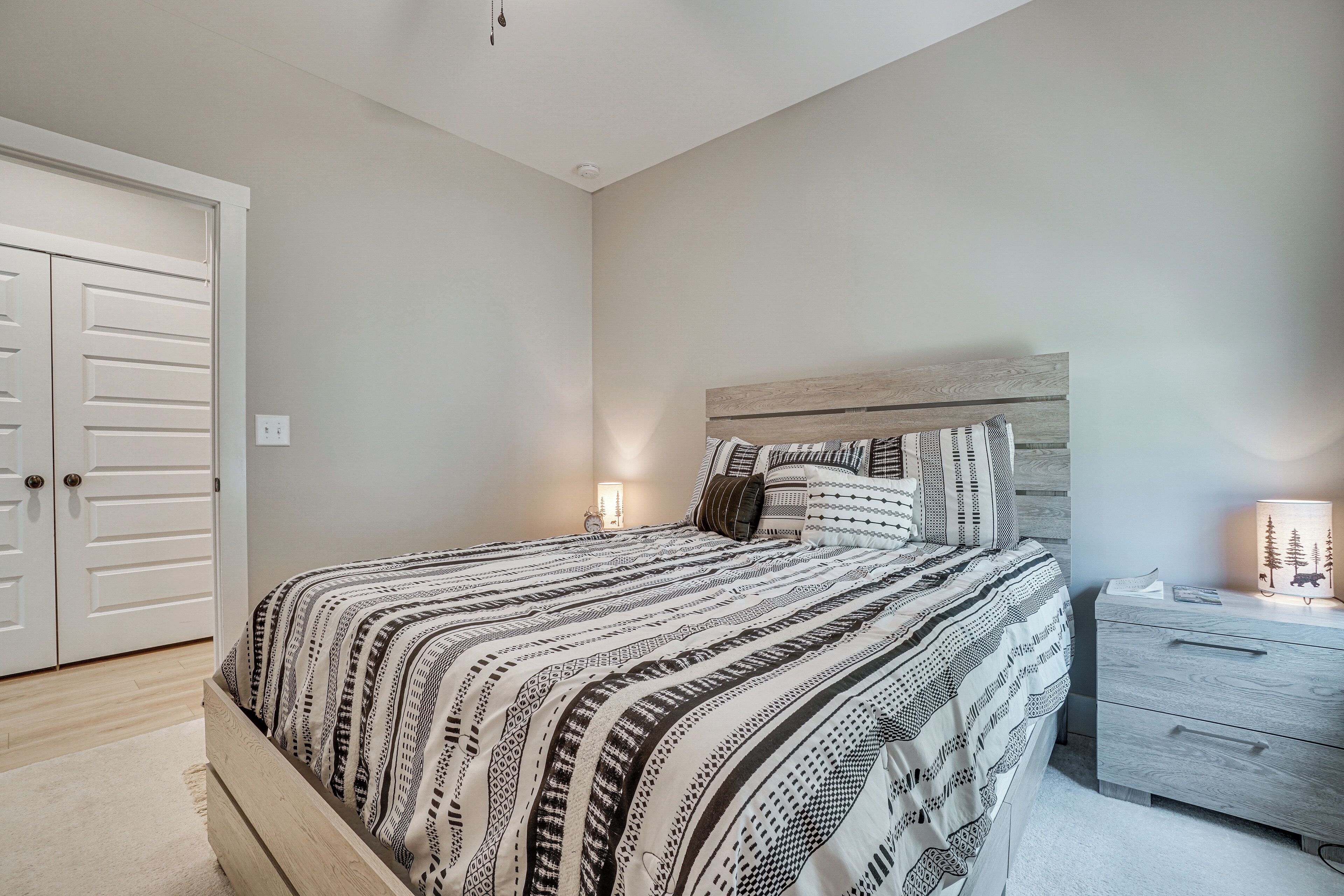 Een slaapkamer met een bed, nachtkastje en kledingkast.