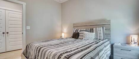 Een slaapkamer met een bed, nachtkastje en kledingkast.