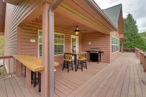 A wooden deck with a table and chairs, a grill, and a ceiling fan. - Hiawassee Riverfront Cabin: 7 Mi to Lake Chatuge! (Hiawassee)
