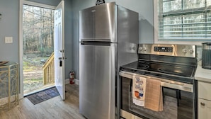 A kitchen with a stainless steel refrigerator, an oven, and a window with blinds. - Atlanta Area Studio ~ 3 Mi to Gas South Arena! (Lawrenceville)