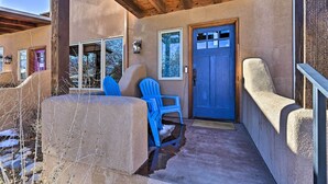 A covered porch with a blue door, blue chairs, and a concrete bench. - 7984: Pet-friendly Townhome w/ Grill! (Salida)