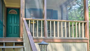 A wooden deck with a railing, a green door, and a window with a view of outdoor furniture. - Cozy Pine Mountain Cabin w/ Screened Porch & Yard! (Pine Mountain)