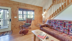 A wooden interior with a sofa, a chair, a table, and a staircase. - Blairsville Cabin in the Pines 1 Mi to Lake (Blairsville)