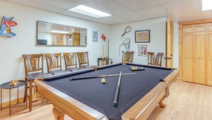 A pool table with chairs, a billiards cue, and a small table with dice. - Game Room & Hot Tub: Upscale Ellijay Cabin! (Ellijay)