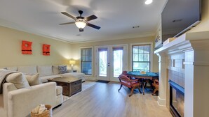 A living room with a sofa, coffee table, and a fireplace. - Lake Oconee Abode w/ Patio, Grill & Fire Pit Table (Eatonton)
