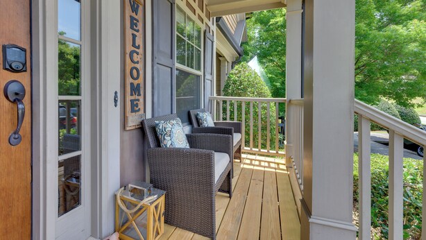 A porch with wicker furniture and a 'WELCOME' sign, wooden railings, and a view of greenery. - Lake Oconee Abode w/ Patio, Grill & Fire Pit Table (Eatonton)