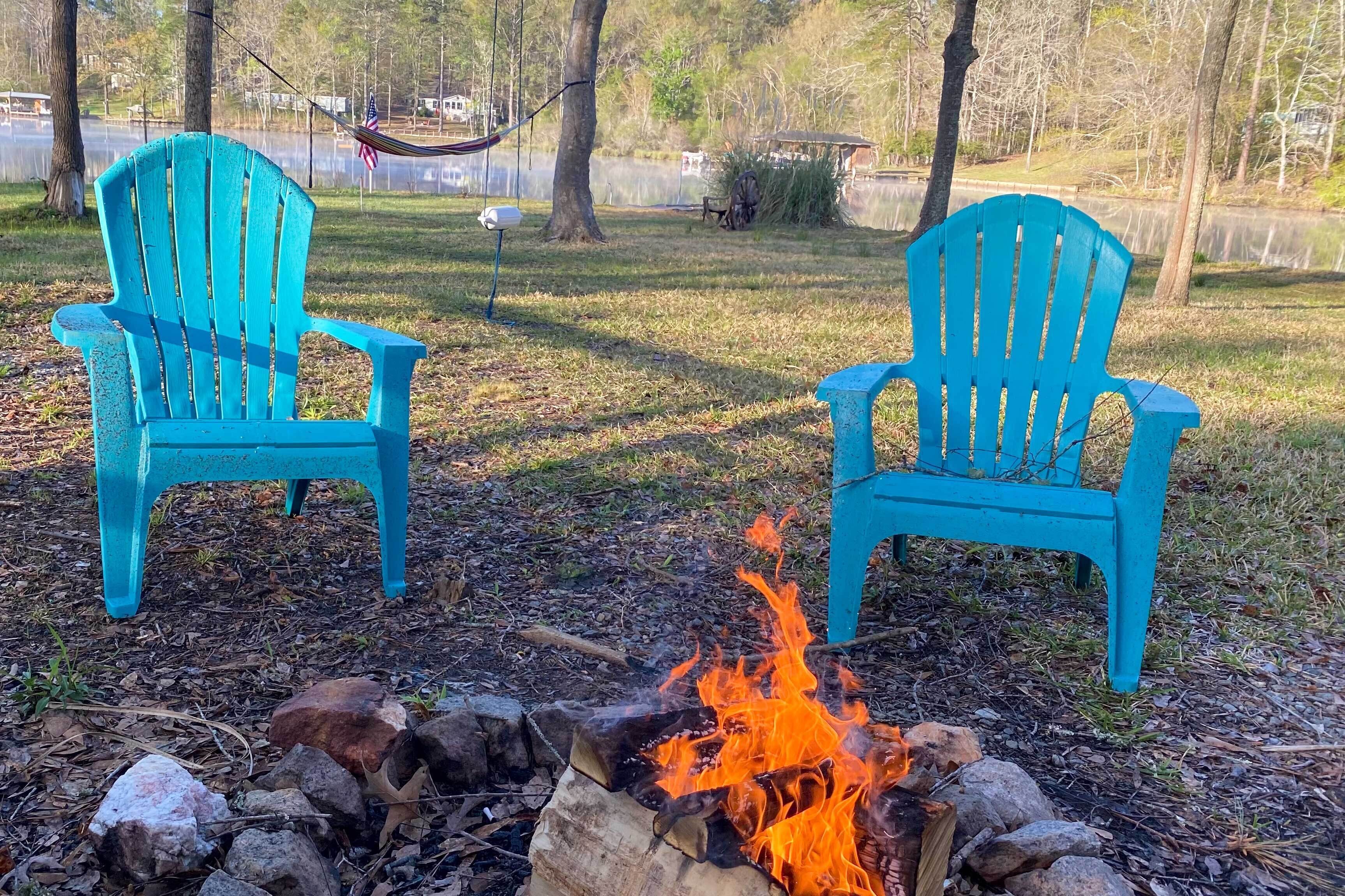 Deux fauteuils Adirondack turquoise, placés face à un feu de camp.