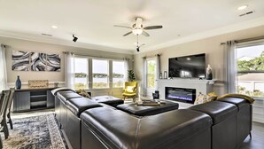 A modern living room with a sectional sofa, a flat-screen TV, and a fireplace. - Waterfront Paradise w/ Deck ~ 1/2 Mi to Beach (Norfolk)