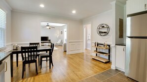 A modern kitchen with a stainless steel refrigerator, wooden flooring, and white cabinetry. - Contemporary Athens Home < 2 Miles to Uga! (Athens)
