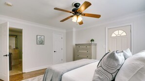 A bedroom with a bed, a ceiling fan, a dresser, and a door leading to another room. - Contemporary Athens Home < 2 Miles to Uga! (Athens)