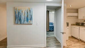 A modern kitchen with white cabinets, a countertop, and a ceiling light.