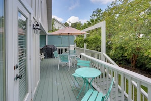 A wooden deck with outdoor furniture, a barbecue grill, and a covered seating area. - Bright St. Simons Island Escape: Walk to the Beach (St. Simons Island)