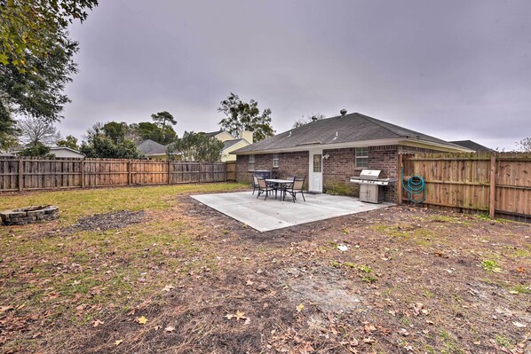 A backyard with a patio, barbecue grill, and a wooden fence. - Savannah Home ~ 9 Mi to Historic District (Savannah)