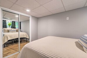 A bedroom with a large bed, a mirror, and a view of another room with a bed and curtains. - 21 Mi to Atlanta: Getaway w/ Fire Pit! (Jonesboro)