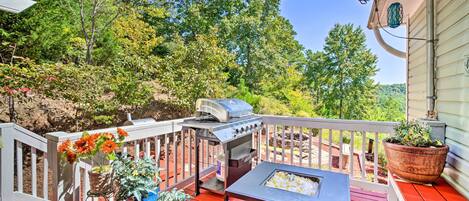 A wooden deck with a grill, potted plants, and a seating area.