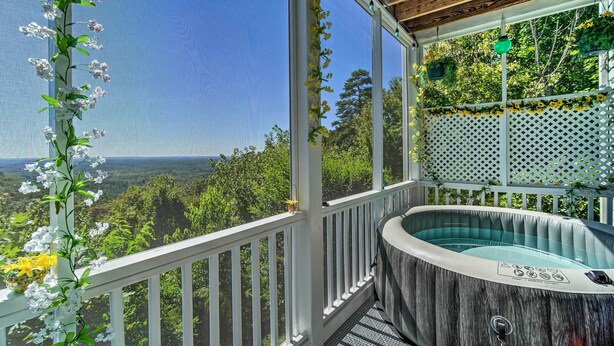 Un bain à remous sur un balcon offrant une vue dégagée sur le paysage.