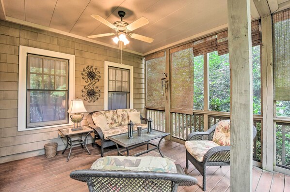 A covered porch with wicker furniture, a ceiling fan, and large windows overlooking greenery. - Big Canoe Retreat w/ Deck & Golf Course Views (Jasper)