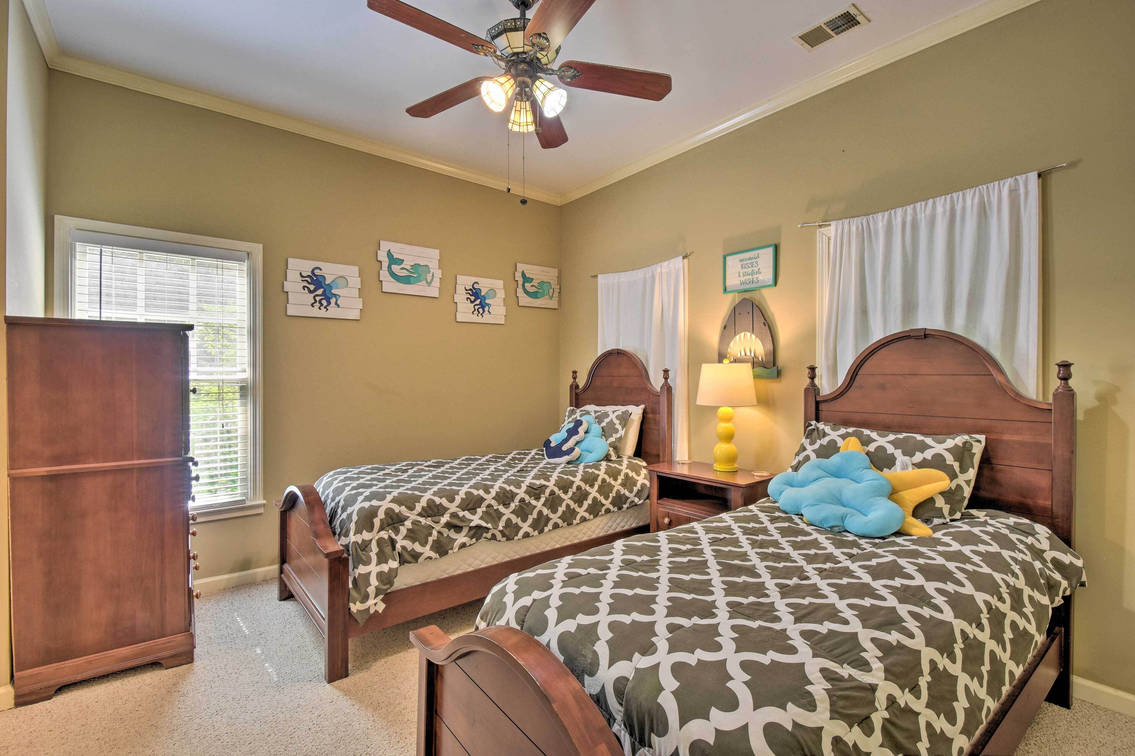 A bedroom with two wooden beds, a ceiling fan, and a window with blinds.