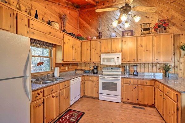 A wooden cabin-style kitchen with a refrigerator, stove, microwave, and a coffee maker. - Hot Tub & Deck! High Country Cabin Near Blue Ridge (Mineral Bluff)