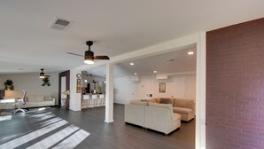 A spacious living area with a large sofa, a dining table, and a kitchen in the background. - Quiet Atlanta Getaway - 16 Mi to Downtown! (Atlanta)