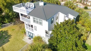A two-story building with a flat roof, multiple balconies, and a fenced yard.