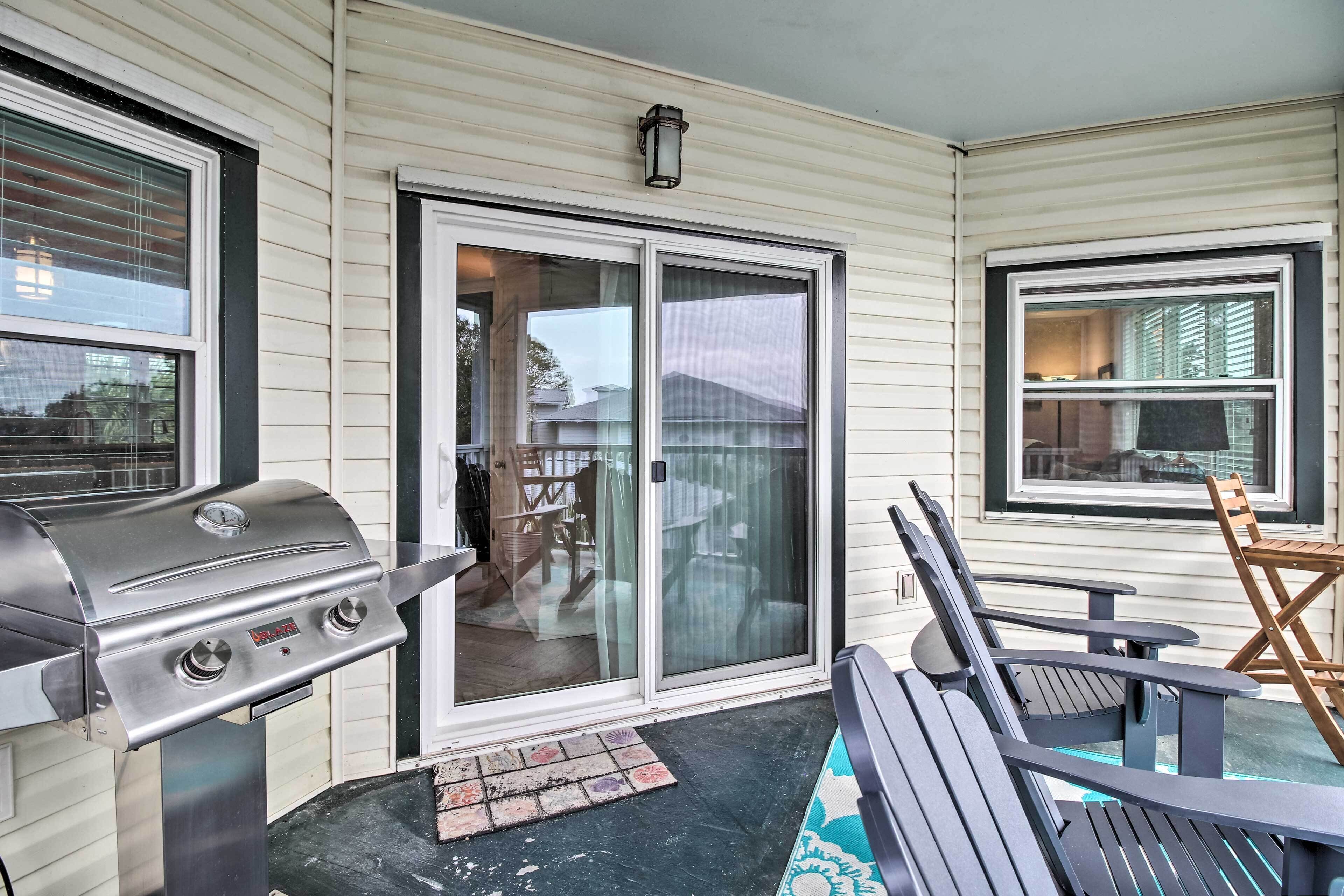 A covered patio area with a grill, sliding glass doors, and outdoor seating.