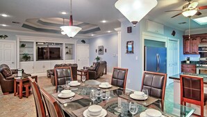 A dining area with a glass table, leather chairs, and pendant lights. - Waterfront Slidell Home w/ Boat Dock & Canal View! (Slidell)