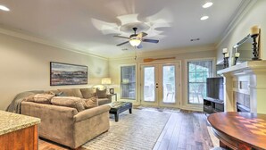 A living room with a ceiling fan, a couch, a coffee table, and a fireplace. - Charming Lake Oconee Retreat - Steps to Lake! (Eatonton)