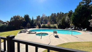 A swimming pool with lounge chairs and a deck area, surrounded by trees and a clear sky. - Charming Lake Oconee Retreat - Steps to Lake! (Eatonton)