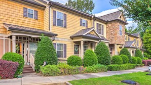 A two-story house with a stone tower, a front porch, and well-maintained landscaping. - Charming Lake Oconee Retreat - Steps to Lake! (Eatonton)