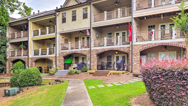 A multi-story building with balconies, outdoor seating, and a well-maintained garden. - Charming Lake Oconee Retreat - Steps to Lake! (Eatonton)