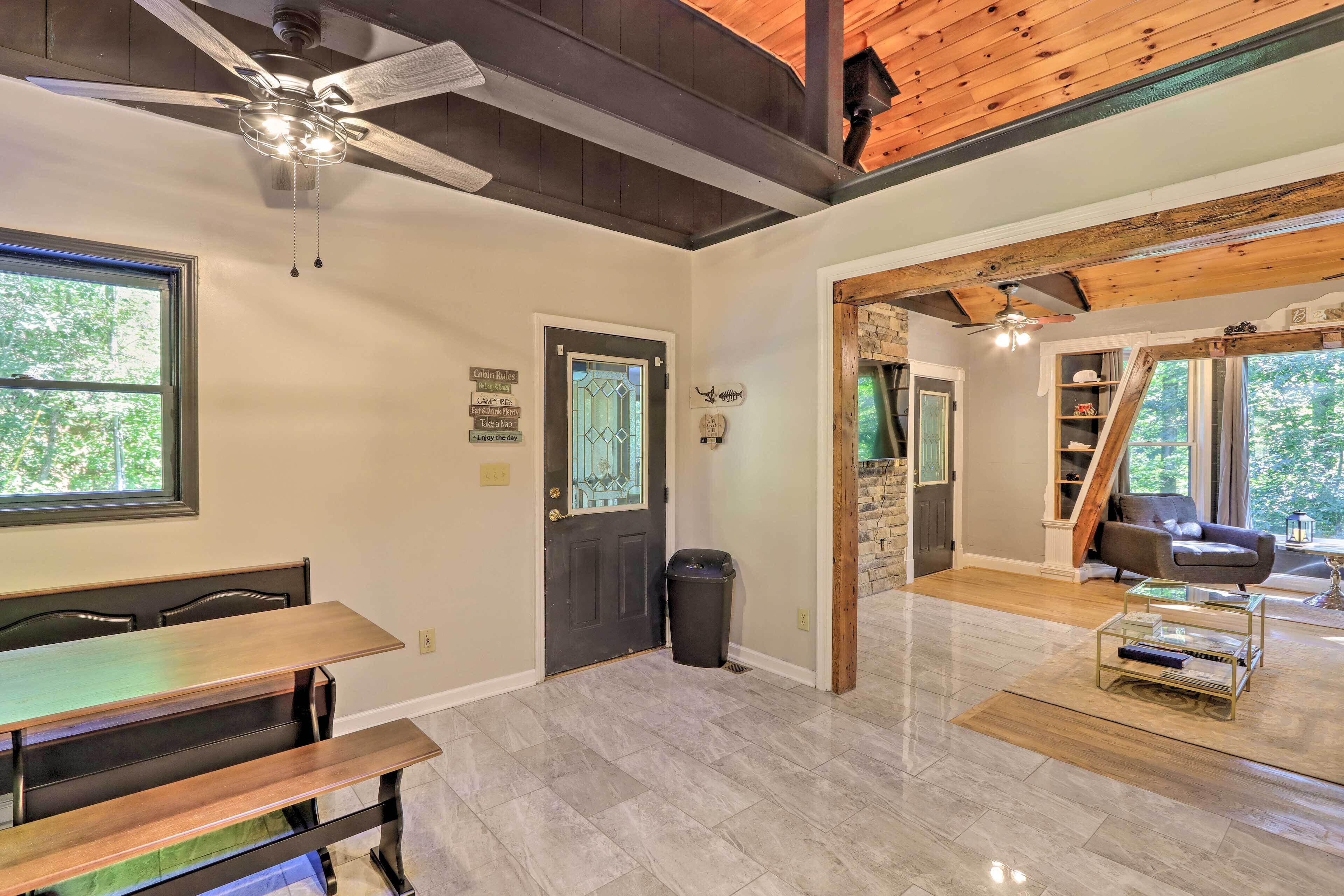 A spacious room with a dining area, a ceiling fan, and a view of the outdoors.