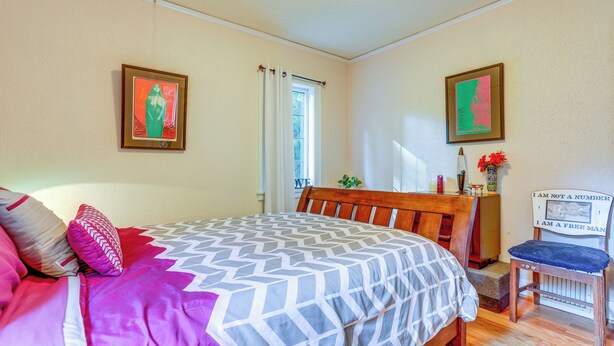 A bedroom with a bed, a chair, a window, and two framed pictures on the wall. - 1 Mi to Park & Waterfront! Seattle Home w/ Balcony (Seattle)