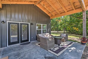 A covered patio area with wicker furniture and a concrete floor. - Cozy Tennessee Country Retreat on 5 Acres! (Pegram)