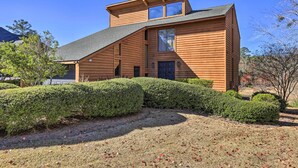 A modern wooden house with a sloped roof, large windows, and a well-maintained garden. - Lakefront Macon Getaway w/ Stunning Boathouse (Macon)