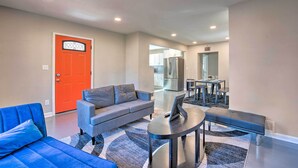 A modern living room with a sofa, a bench, and a coffee table. A kitchen area is visible in the background. - Central Location! ATL Stay 5 Mi to Mercedes-benz (Atlanta)