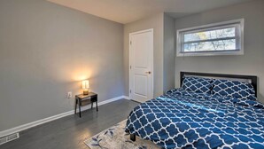 A bedroom with a bed, a nightstand with a lamp, a door, and a window. - Central Location! ATL Stay 5 Mi to Mercedes-benz (Atlanta)