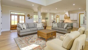 A spacious living room with a large sectional sofa, a coffee table, and a patterned rug.