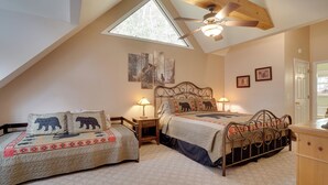 A bedroom with two beds, a skylight, a ceiling fan, and artwork on the walls. - Enchanted Forest Cottage w/ Hot Tub! (Hiawassee)