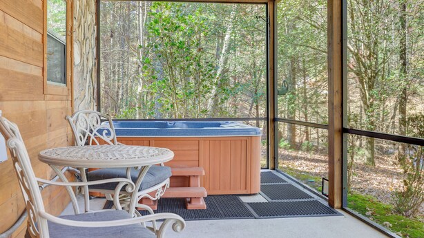 A wooden cabin with a hot tub, a table, and chairs. - Hot Tub & Game Room: Blue Ridge Getaway (Blue Ridge)