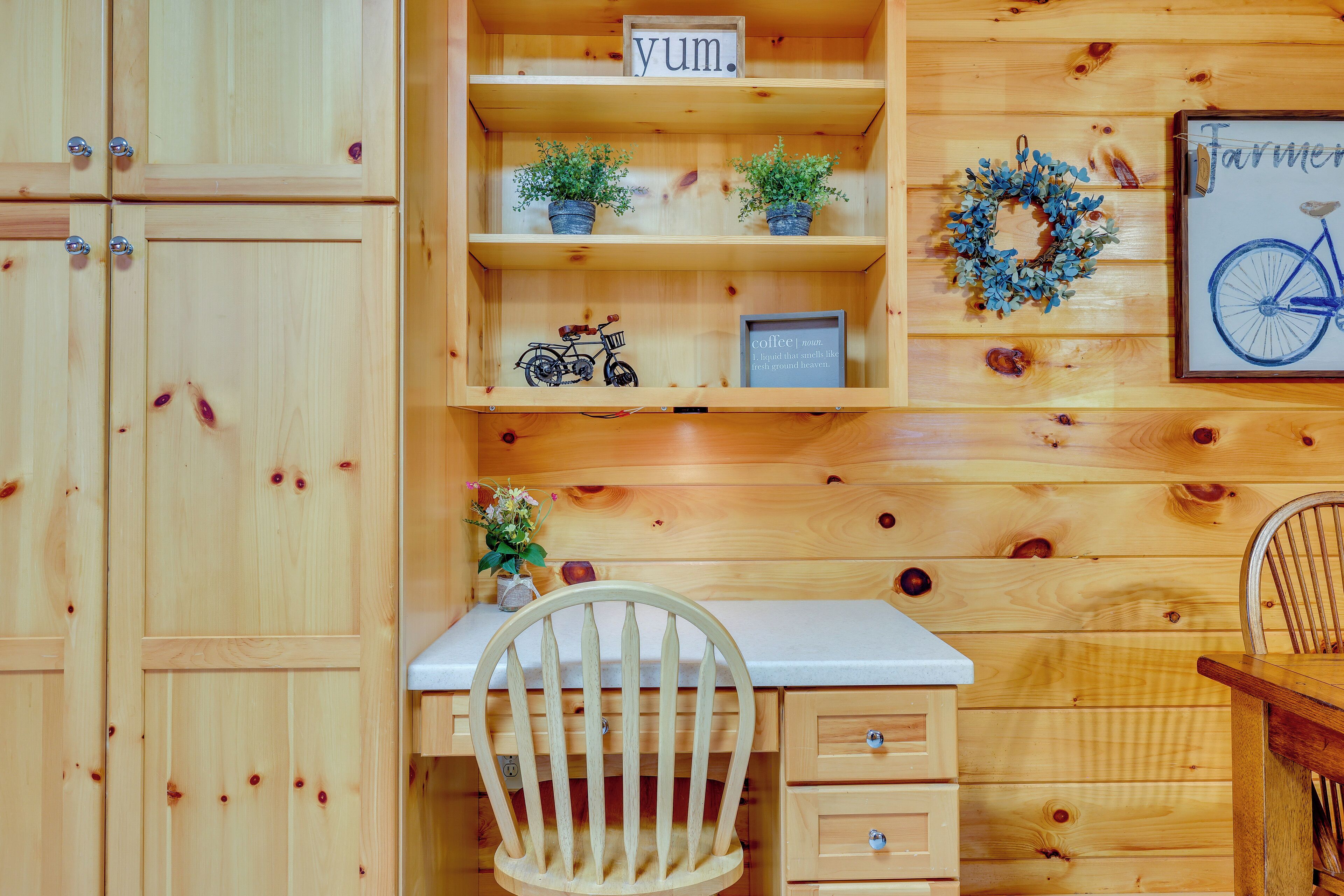 Ein Holzblockhaus-Interieur mit Schreibtisch, Stuhl, Regalen und einem Fahrrad.