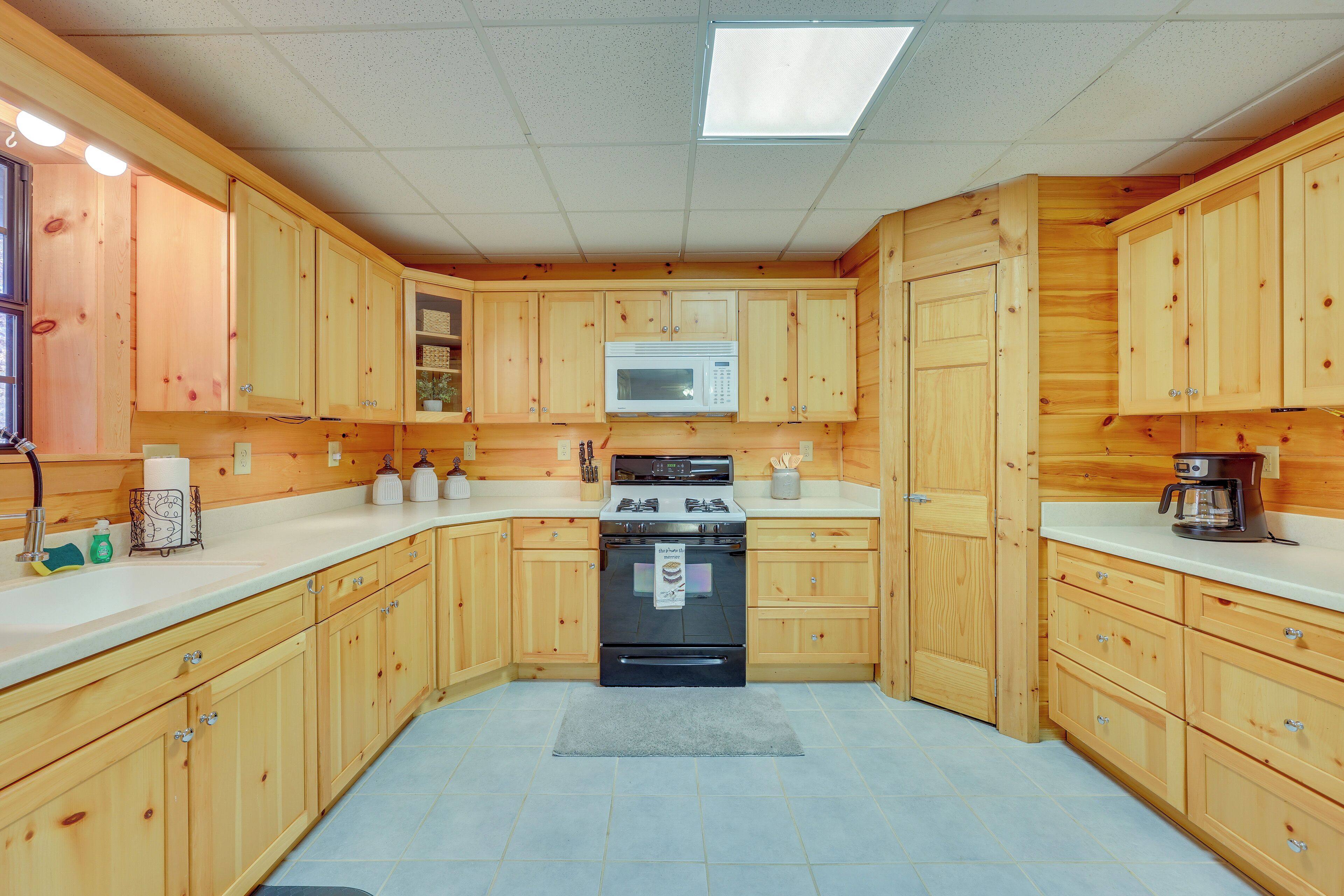 A kitchen with wooden cabinets, a microwave, a stove, and a coffee maker.