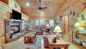 A cozy log cabin interior with a fireplace, comfortable seating, and a television. - Hot Tub & Game Room: Blue Ridge Getaway (Blue Ridge)