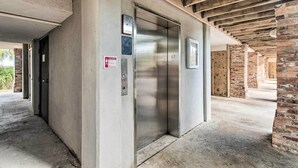 Een lift in een gebouw met zichtbare houten balken en bakstenen muren.