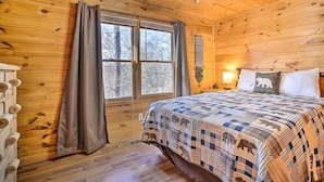 A wooden cabin bedroom with a bed, curtains, a ceiling fan, and a window. - 'serenity Cabin' w/ Furnished Deck (Mineral Bluff)