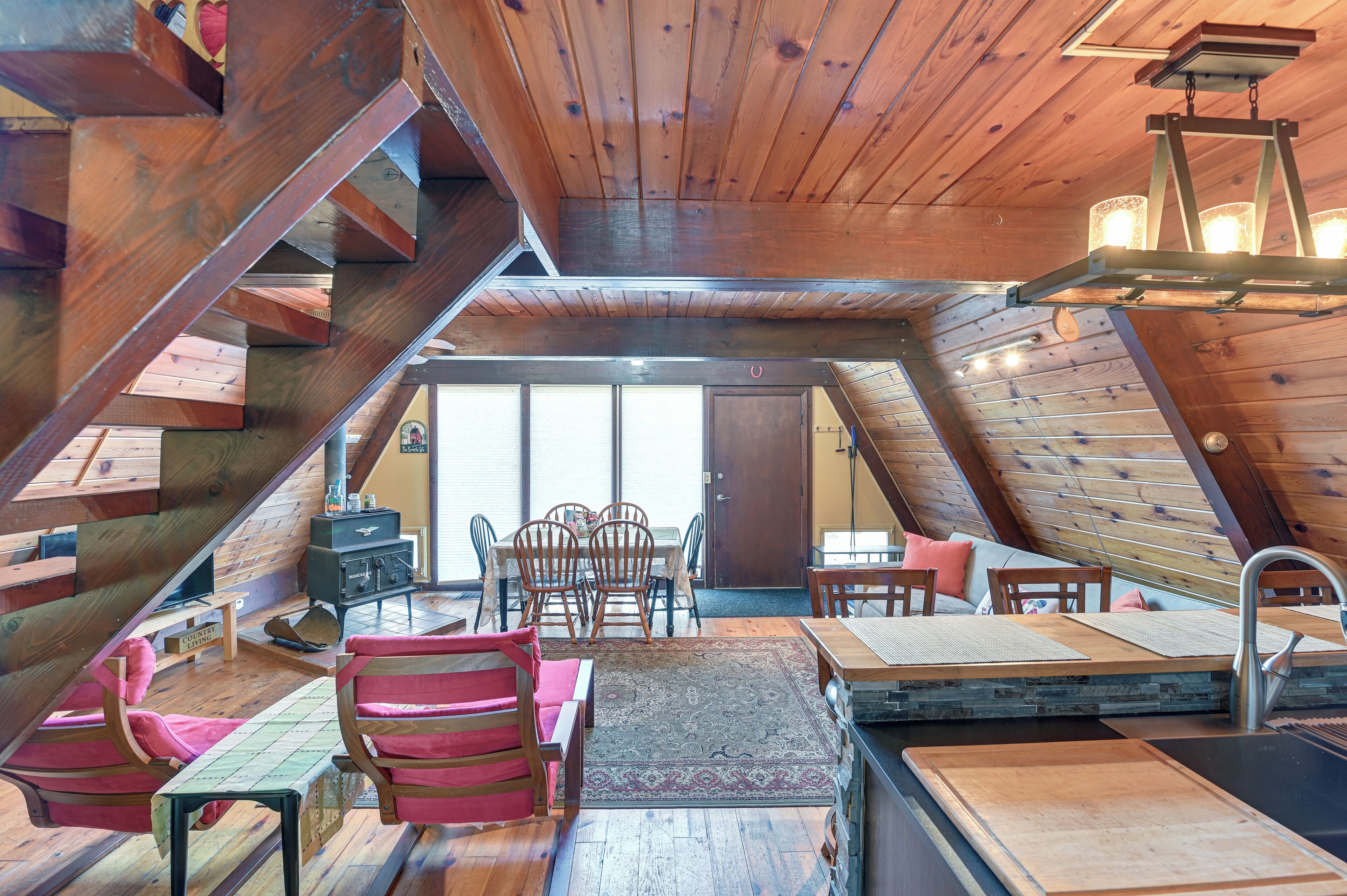 Un interior de madera con comedor, cocina y escalera.