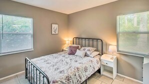 Un dormitorio con cama, mesitas de noche y una lámpara en el techo.